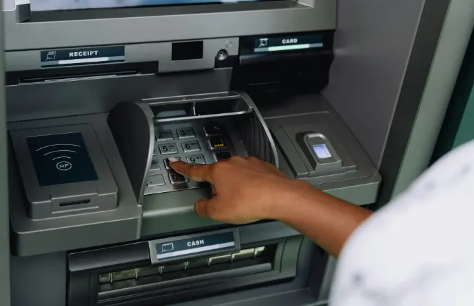 a person using an atm machine to pay money